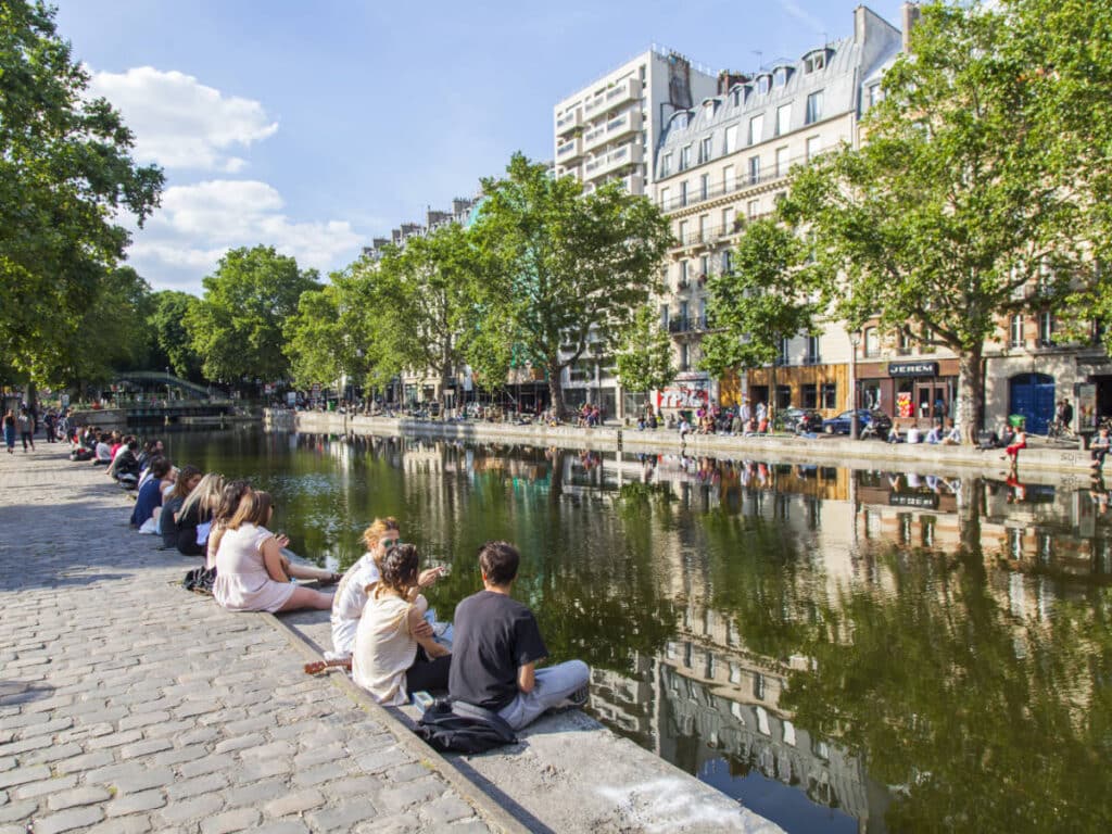 People sitting along an embankment in 10th arrondissement