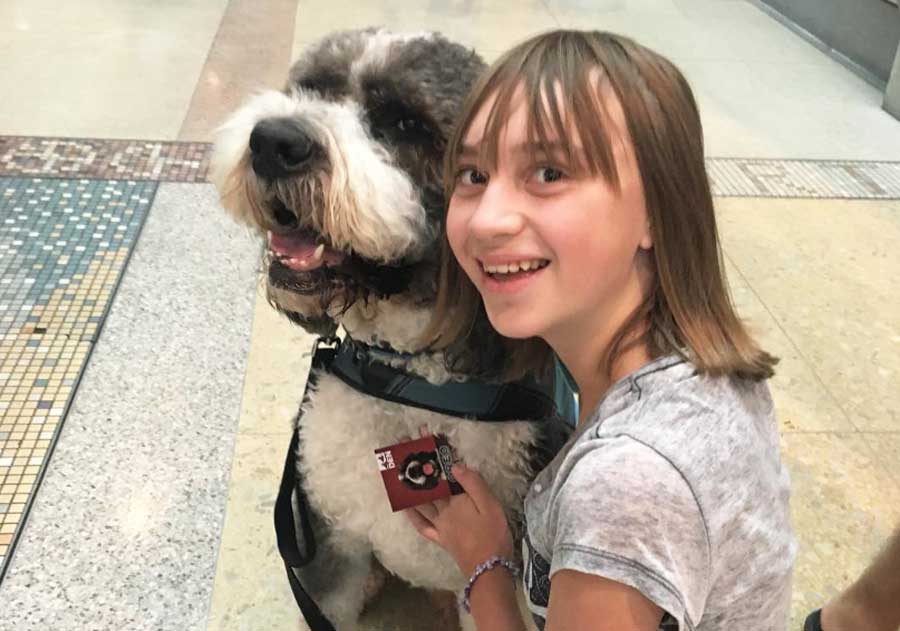A girl smiling for a photo with a dog