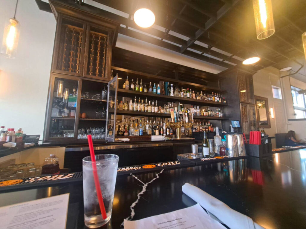 A glass of water with a red straw at a bar counter