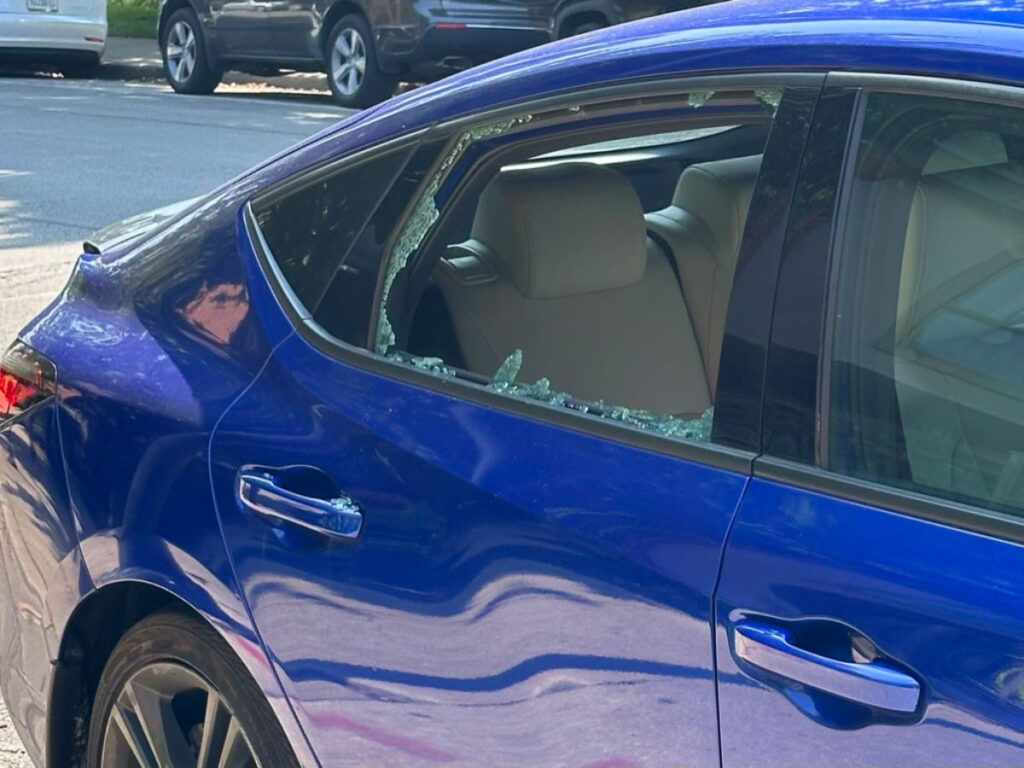 A blue car with a broken window