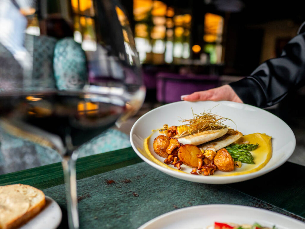 A close-up of a gourmet dish being served in an elegant restaurant
