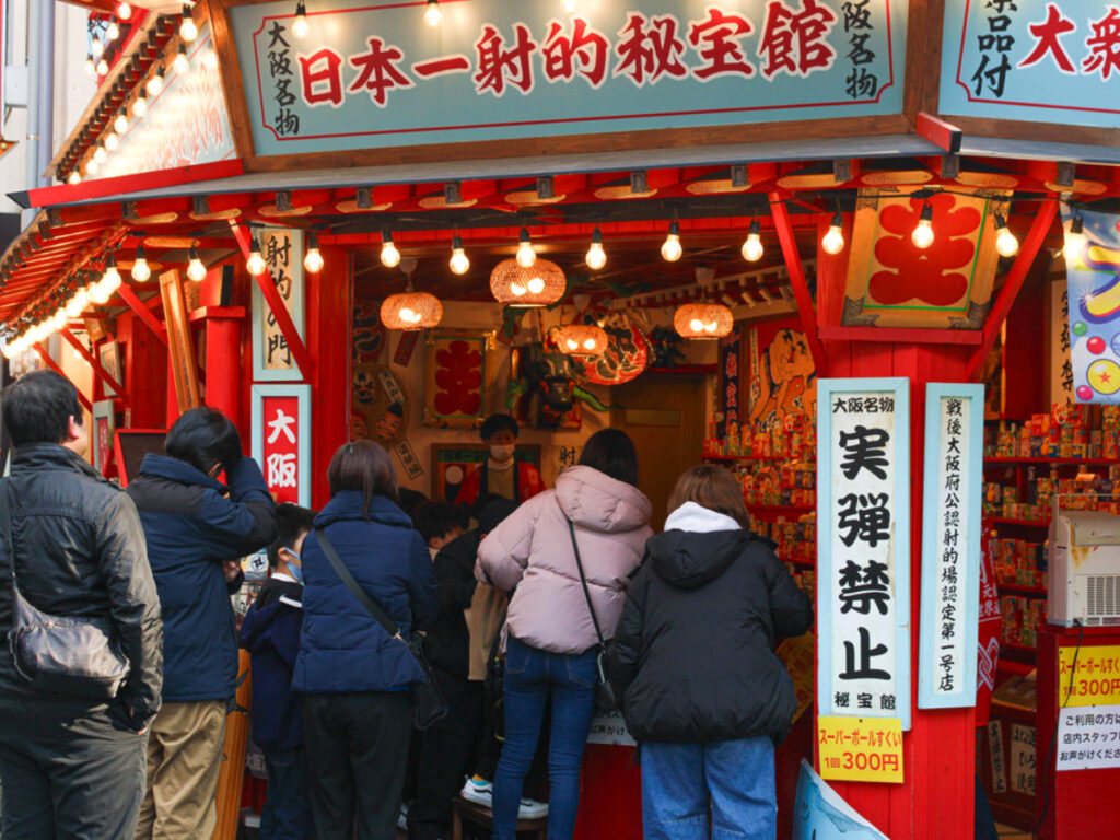 A group of people gathered in front of a shop in the Naniwa district of Osaka