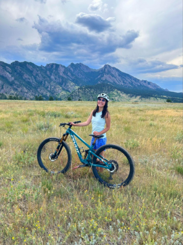The author Abigail mountain biking beneath the Flatirons