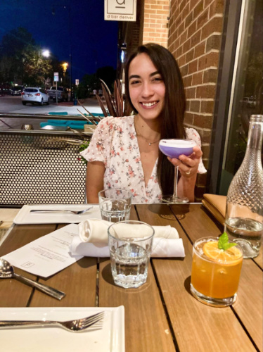 Travel Lemming Editor Abigail Bliss, holding a glass of cocktail at D Bar Denver