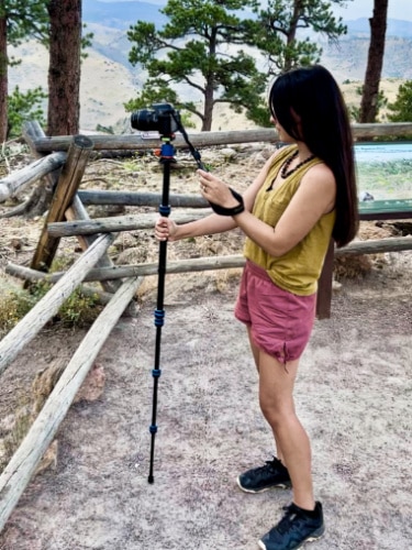 The author Abigail Bliss, holding a monopod with a mounted DSLR