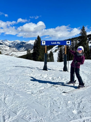 Travel Lemming Editor Abigail Bliss, posing for a photo beside a signage in Vail