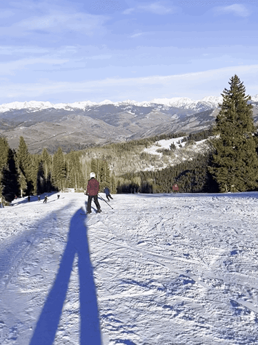 The author Abigail Bliss, skiing on Gold Dust with scenic mountain views in the background