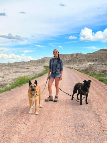The author Abigail Bliss and her dogs, posing for a photo at Badlands National Park