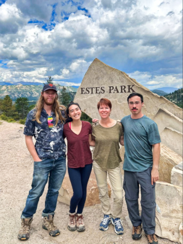 Travel Lemming Editor Abigail Bliss and her family, posing for a photo at the Estes Park landmark signage