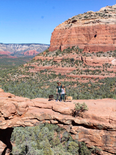 The author Abigail Bliss with her husband and dogs, posing in the middle of the Devil's Bridge in Sedona