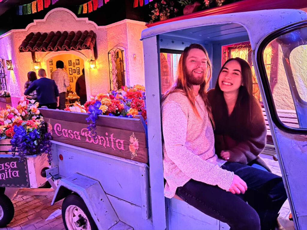 Travel Lemming Editor Abigail Bliss and her husband, posing for a photo while sitting on a vehicle at Casa Bonita