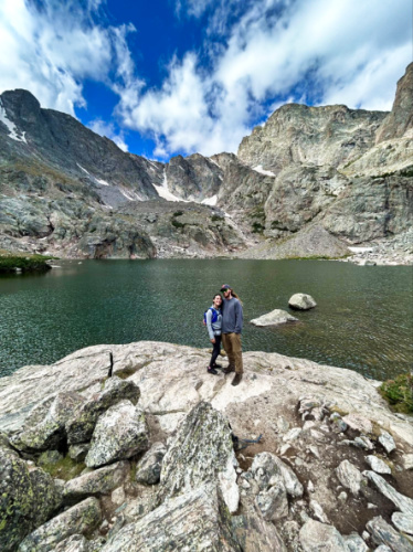 Travel Lemming Editor Abigail Bliss and her husband, posing for a photo at Rocky Mountain National Park with a scenic mountain views in the background