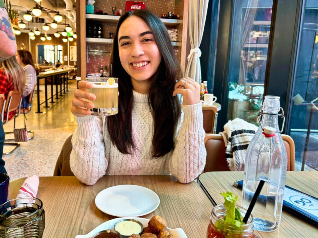 Travel Lemming Editor Abigail Bliss, holding a glass of cocktail at The Original