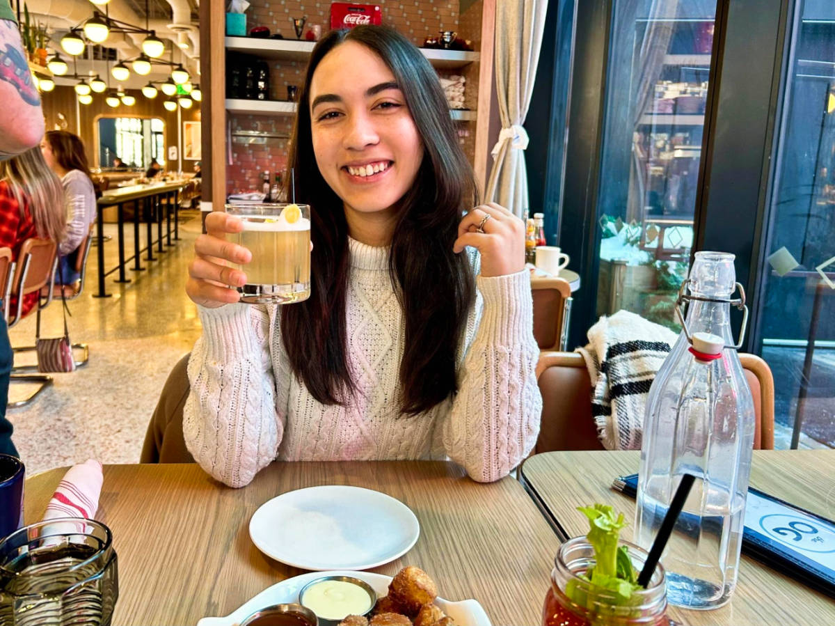 Travel Lemming Editor Abigail Bliss, holding a glass of cocktail at The Original