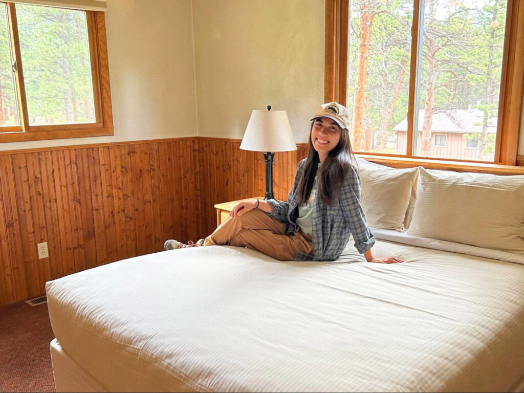 The author Abigail Bliss sitting on a bed in YMCA of the Rockies