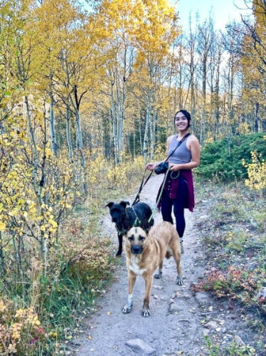 The author Abigail Bliss with her dogs, posing for a photo at the trail of Golden Gate Canyon State Park