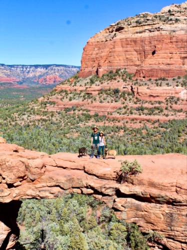 Travel Lemming Editor Abigail Bliss and her husband, posing for a photo at the Devil’s Bridge with their dogs