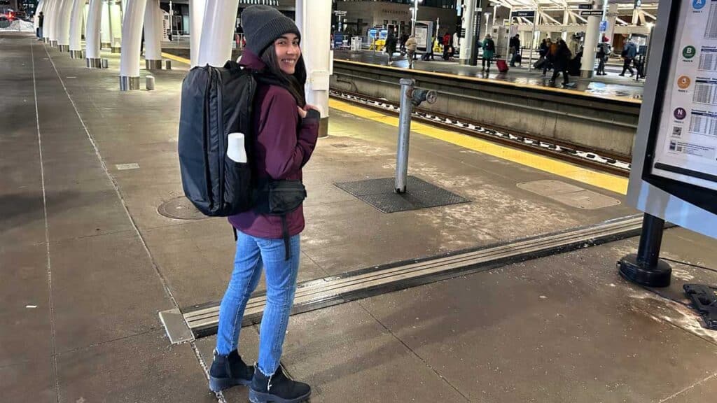 The author smiling during a low temperature carrying her Tortuga Travel Backpack