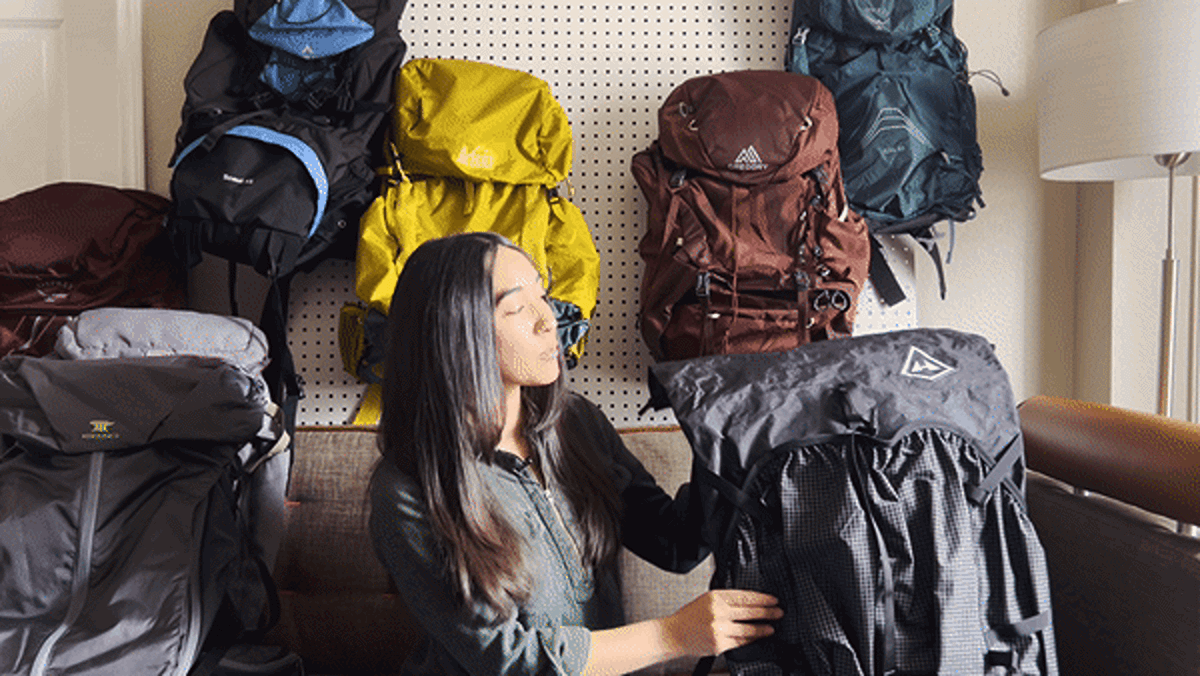 The author, Abigail, demonstrates the roll-top closure of the Hyperlite Mountain Gear Southwest Backpack