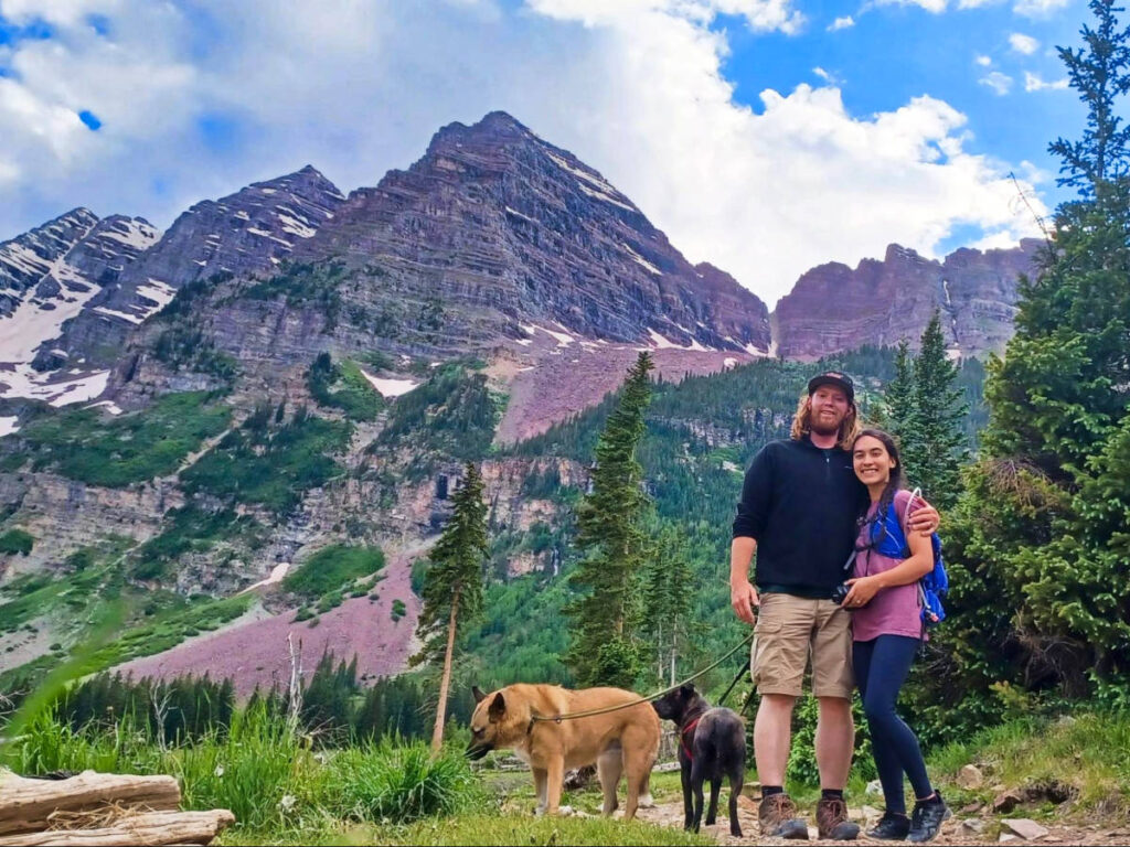Travel Lemming Editor, Abigail Bliss, her husband, and puppies with the Maroon Bells in the background