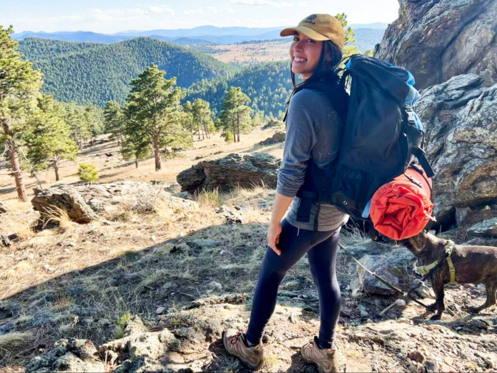 The author, Abigail posing while carrying her Teton Sports Scout Backpack with a scenic view in the background