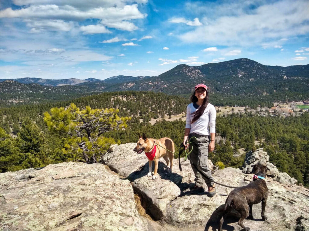 The author Abigail holding the leash of her dogs at Evergreen Mountain