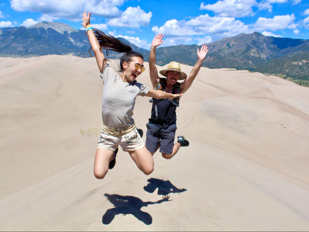 Travel Lemming Editor, Abigail Bliss and her brother, posing for a photo while jumping at the Great Sand Dunes National Park and Preserve