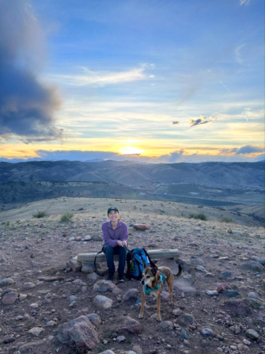 The author Abigail Bliss and her dog sitting on a wood at the Green Mountain