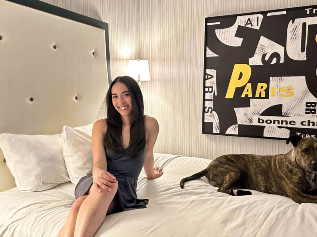 Travel Lemming editor Abigail Bliss and her dog, sitting on the bed in Paris Las Vegas Hotel & Casino