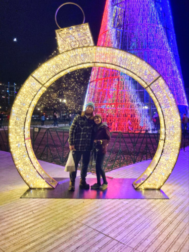 Travel Lemming editor Abigail and her husband posing for a photo under the holiday decors on December