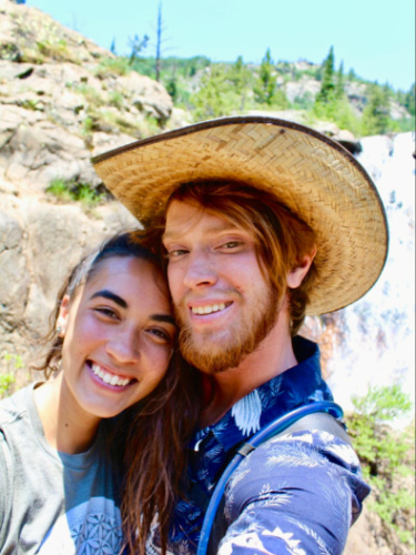 Travel Lemming Editor, Abigail Bliss and her husband, posing for a photo with mountain view in the background