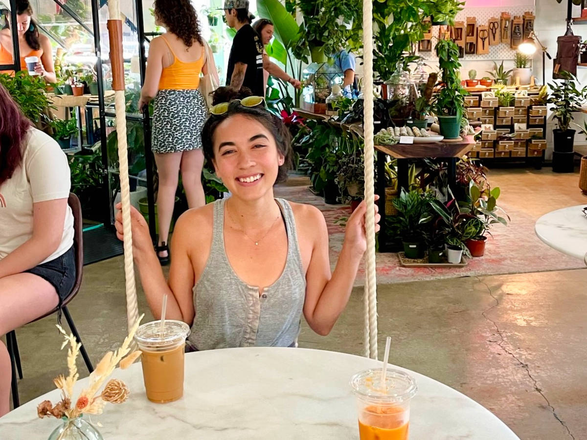 Author Abigail sitting on a swing and enjoying her coffee at Dandy Lion Coffee Co