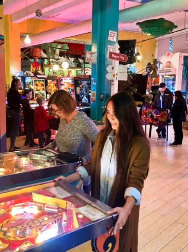 Travel Lemming editor Abigail Bliss playing the retro arcade games at Superelectric Pinball Parlor