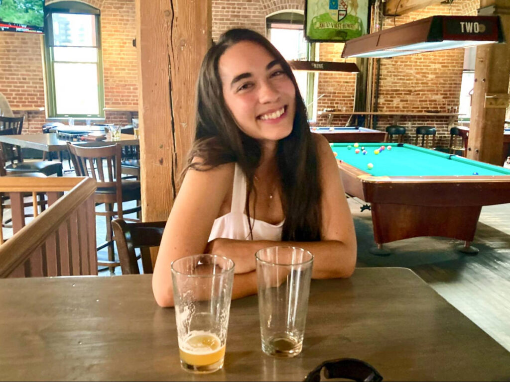 Travel Lemming Editor, Abigail with two empty glasses at Wynkoop Brewing Company