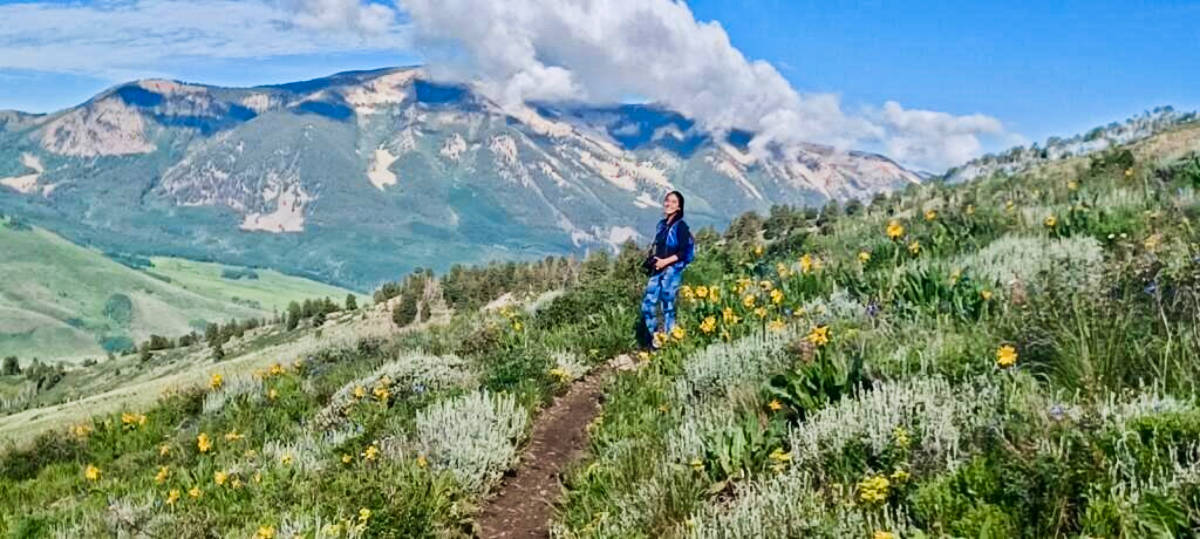 Travel Lemming Editor, Abigail Bliss posing for a photo in the middle of the wildflowers
