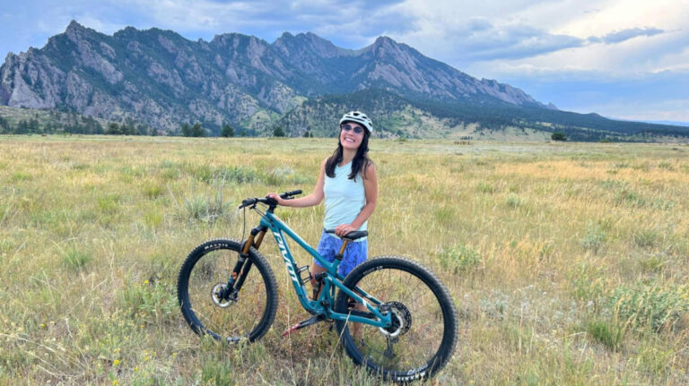 Travel Lemming editor, Abigail Bliss holding her mountain bike in Boulder