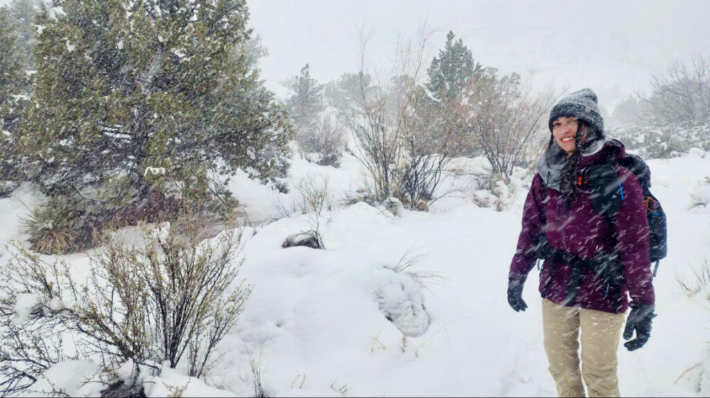 The author, Abigail, posing under the heavy snow in Utah