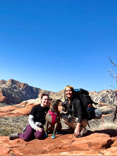 Abigail with her friends posing with a scenic view in the background