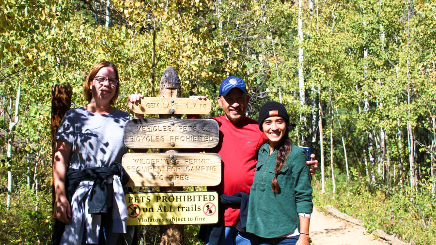 The author, Abigail posing with her parents at the Gem Lake trail signage