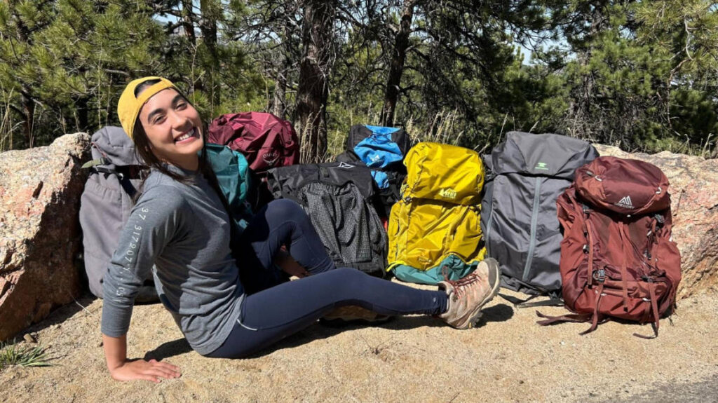 The author posing for a photo with the best backpacking backpacks