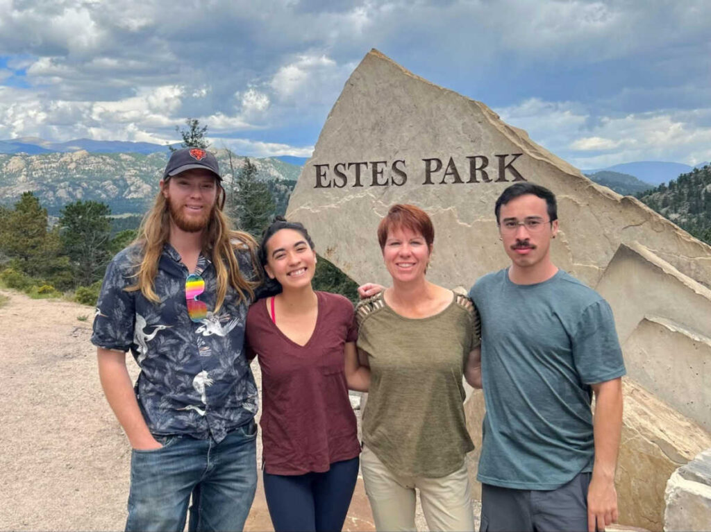The author Abigail with her family at the signage of Estes Park