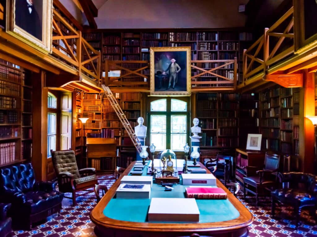 Interior view of John Adams house with an oval table in the middle surrounded by book shelves