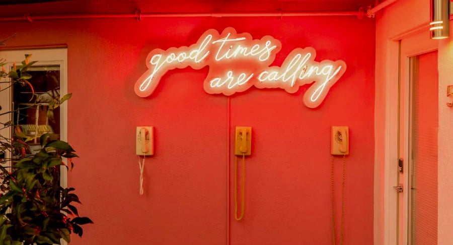 View of the interior of a rental place with a neon sign of "good times are calling".