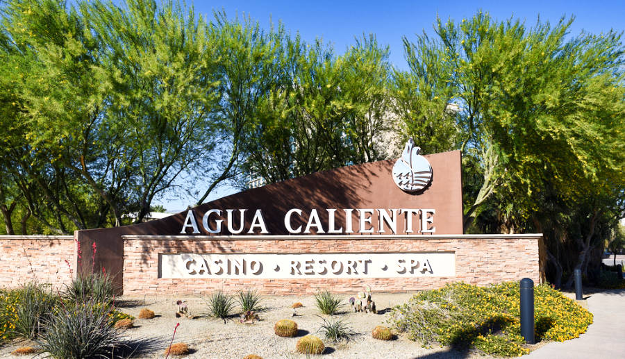 A big welcome sign of Agua Caliente Casino on a brick wall at the entrance.