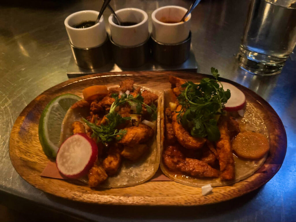 The best al pastor tacos on the wooden plate from Casa Enrique