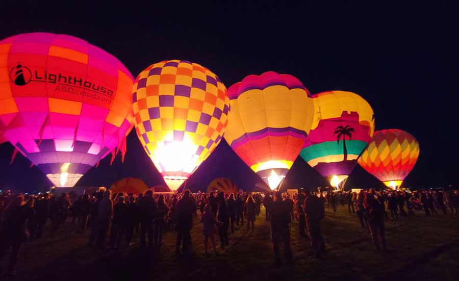 View of people and colorful hot air balloons in Albuquerque during Balloon Fiesta Park