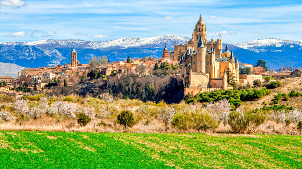 View of the Alcazar of Segovia in the distance with mountain ranges in the background
