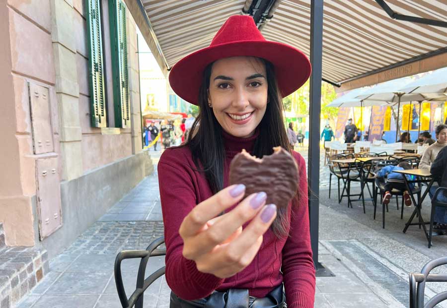 Clara smiling while holding an Alfajor in La Boca