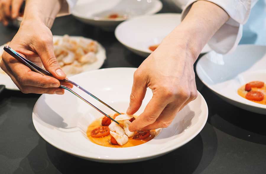 A chef preparing a dish in Alinea