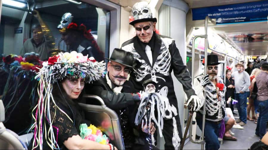 The author Betty Hurd on a skeleton costume with the locals inside the SunLink streetcar in Tucson